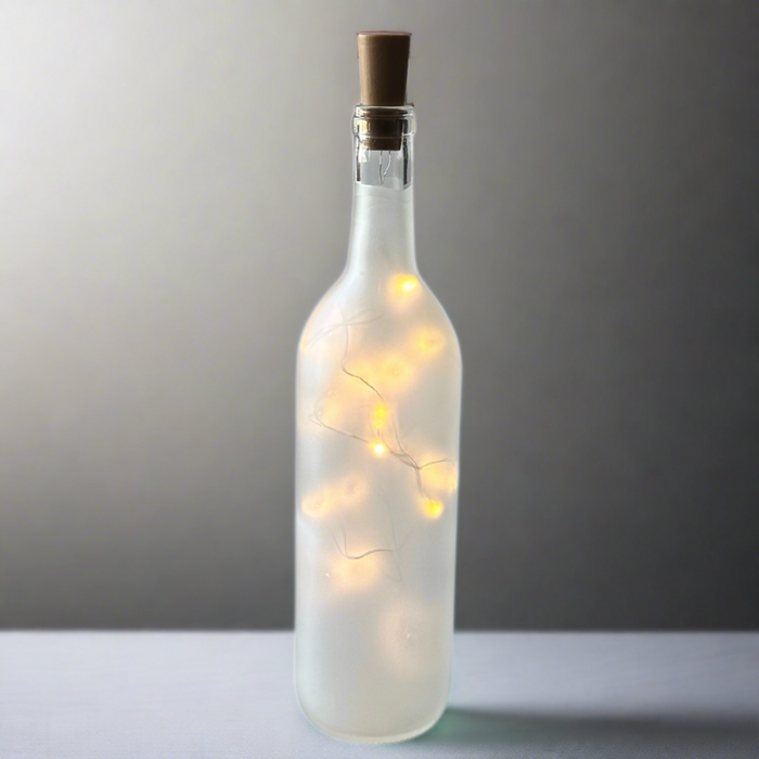 frosted wine bottle with warm white lights inside