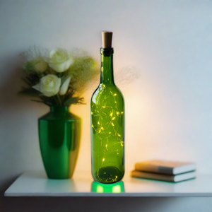 green wine bottle with fairy lights inside, sitting on a bookshelf near green vase and books
